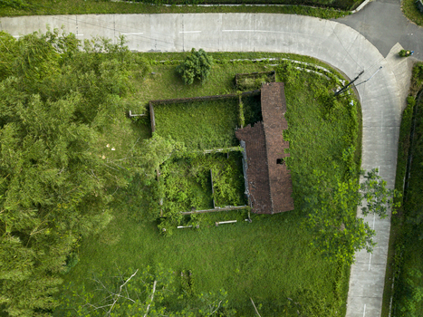 Aerial view of Houses Damaged by Mount Merapi Eruption with collapsed roofs and overgrown vegetation near a curved road in Cangkringan Special Region of Yogyakarta Indonesia. Aerial view of Houses Damaged by Mount Merapi Eruption with collapsed roofs and overgrown vegetation near a curved road in Cangkringan Special Region of Yogyakarta Indonesia.
