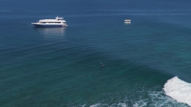 Aerial view of a boat and a surfer on a wave Maldives. Aerial view of a boat and a surfer on a wave Maldives.