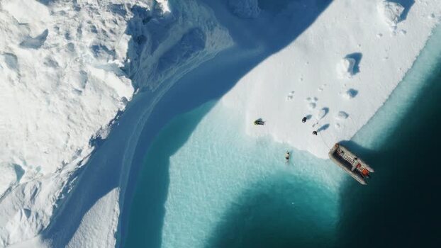 Aerial view of zodiac boat at iceberg in Greenland. Aerial view of zodiac boat at iceberg in Greenland.