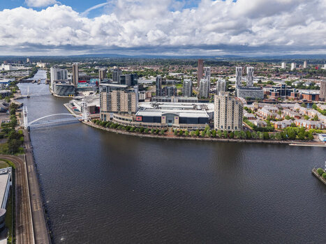 Aerial view of MediaCityUK with modern office buildings residential apartments and the footbridge over the Manchester Ship Canal in Salford England United Kingdom. Aerial view of MediaCityUK with modern office buildings residential apartments and the footbridge over the Manchester Ship Canal in Salford England United Kingdom.