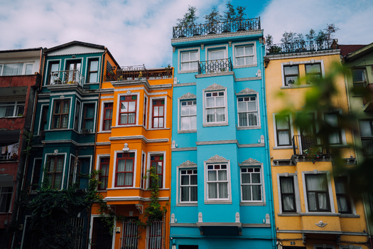 Istanbul Turkiye 06 October 2019 View of vibrant houses stand shoulder to shoulder their facades awash in turquoise golden yellow and sunset orange a lively spectacle. Istanbul Turkiye 06 October 2019 View of vibrant houses stand shoulder to shoulder their facades awash in turquoise golden yellow and sunset orange a lively spectacle.
