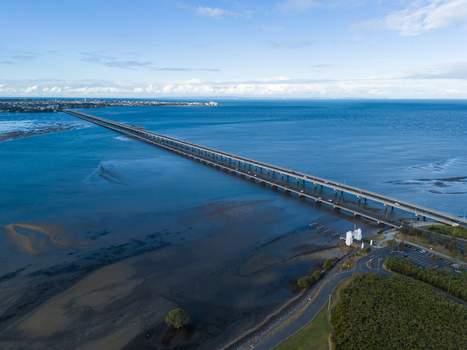 Aerial view of Ted Smout Memorial Bridge spanning across the water with coastal shoreline and clear blue sky in Brighton Queensland Australia. Aerial view of Ted Smout Memorial Bridge spanning across the water with coastal shoreline and clear blue sky in Brighton Queensland Australia.