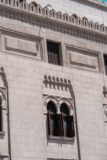 View of the historic stone facade and arched windows with wooden shutters of Al Azhar Mosque in Cairo Egypt. View of the historic stone facade and arched windows with wooden shutters of Al Azhar Mosque in Cairo Egypt.