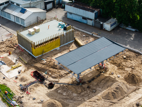 Riga Latvia 04 July 2026 Aerial view of a new gas station under construction in the Zemgale suburb showing an unfinished building structure and metal canopy frame on sandy ground.