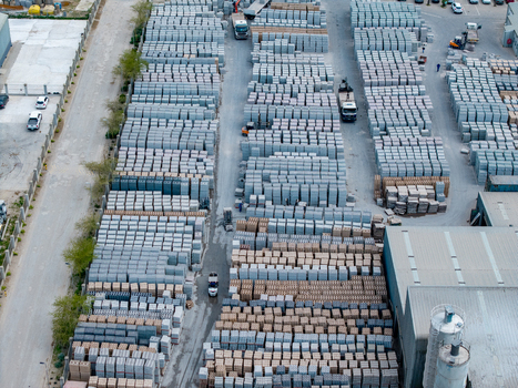 Aerial view of the industrial yard in Philippi featuring rows of stacked concrete blocks and paving materials with trucks in the facility in Cape Town Western Cape South Africa.