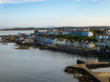 Aerial view of Bangor Harbour and Town featuring colorful houses along the waterfront rocky coastline and calm sea Bangor Northern Ireland United Kingdom.