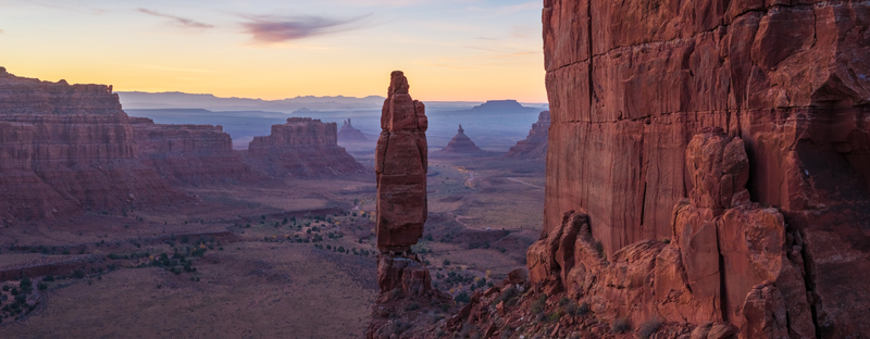 Aerial view of Bears Ears National Monument featuring towering red sandstone rock formations and desert landscape under a soft sunrise sky in San Juan County Utah United States. Aerial view of Bears Ears National Monument featuring towering red sandstone rock formations and desert landscape under a soft sunrise sky in San Juan County Utah United States.