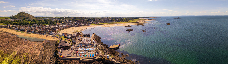 Aerial view of the harbor filled with small boats the sandy beach and the North Berwick Law hill in the background North Berwick Scotland United Kingdom. Aerial view of the harbor filled with small boats the sandy beach and the North Berwick Law hill in the background North Berwick Scotland United Kingdom.