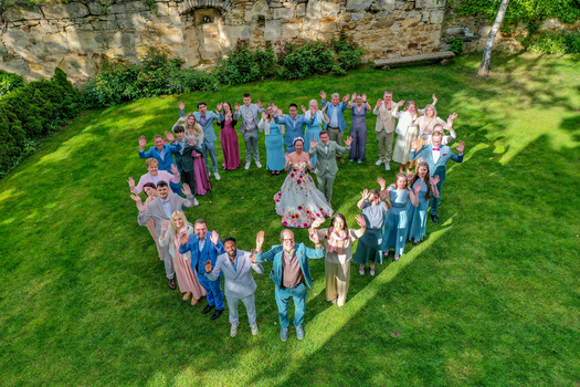 Wiesenthau Germany 02 May 2026 Aerial view of a wedding party forming a heart shape on the lawn of Schloss Wiesenthau with a bride in a floral dress and guests waving. Wiesenthau Germany 02 May 2026 Aerial view of a wedding party forming a heart shape on the lawn of Schloss Wiesenthau with a bride in a floral dress and guests waving.