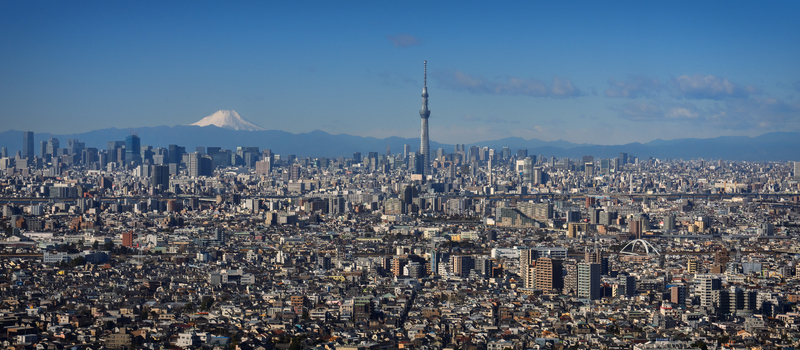 Aerial view of Tokyo Skytree and the sprawling urban landscape with Mount Fuji visible in the distance under a clear blue sky Tokyo Japan. Aerial view of Tokyo Skytree and the sprawling urban landscape with Mount Fuji visible in the distance under a clear blue sky Tokyo Japan.