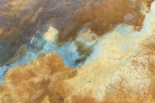 Aerial view of the colorful mineral deposits and cracked earth textures of the open pit mines in Minas de Riotinto Andalusia Spain.