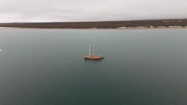 Aerial view of a wooden sailboat near the coast of Greenland. Aerial view of a wooden sailboat near the coast of Greenland.