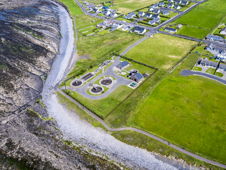 Aerial view of the water purification plant situated along the rocky coastline near residential houses and green fields in Enniscrone County Sligo Ireland. Aerial view of the water purification plant situated along the rocky coastline near residential houses and green fields in Enniscrone County Sligo Ireland.