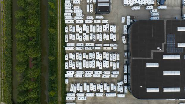 Purmerend Netherlands 15 June 2026 Aerial view of a storage lot filled with rows of white caravans next to a dark industrial building and a canal lined with trees. Purmerend Netherlands 15 June 2026 Aerial view of a storage lot filled with rows of white caravans next to a dark industrial building and a canal lined with trees.