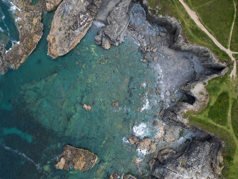 Aerial view of Godrevy Beach featuring turquoise ocean water rugged rock formations and green clifftop paths in Gwithian England United Kingdom. Aerial view of Godrevy Beach featuring turquoise ocean water rugged rock formations and green clifftop paths in Gwithian England United Kingdom.