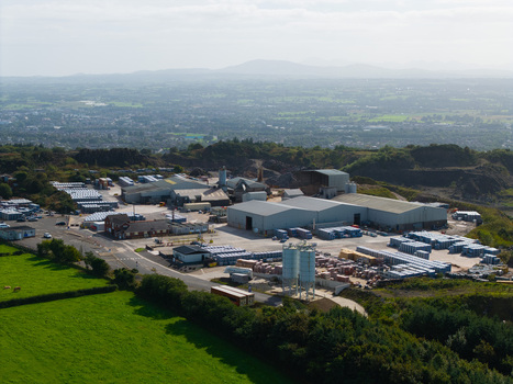 Aerial view of an industrial facility and storage yard with rows of stacked materials metal silos and surrounding green fields in Lisburn Northern Ireland United Kingdom. Aerial view of an industrial facility and storage yard with rows of stacked materials metal silos and surrounding green fields in Lisburn Northern Ireland United Kingdom.