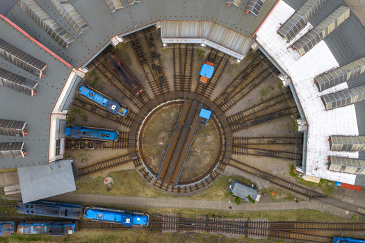 Aerial view of a railway roundhouse with a central turntable and blue locomotives parked on radial tracks in Breclav South Moravian Region Czechia.