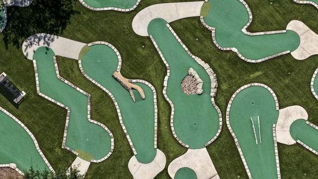 Aerial view of a miniature golf course featuring green putting surfaces stone borders and obstacles at Windward Ranch Boulevard in St. Johns County Florida United States. Aerial view of a miniature golf course featuring green putting surfaces stone borders and obstacles at Windward Ranch Boulevard in St. Johns County Florida United States.