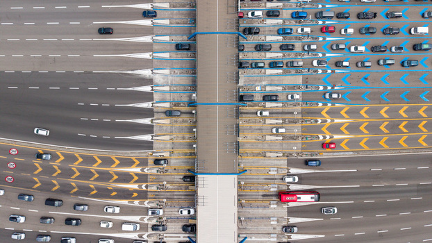 Aerial view of the Milano Sud toll plaza on the A1 motorway featuring heavy vehicle traffic highway infrastructure and transportation systems in Melegnano Lombardy Italy.