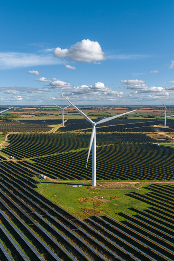 Aerial view of Chelveston Renewable Energy BESS featuring rows of solar panels and wind turbines under a blue sky with scattered clouds in Chelveston England United Kingdom. Aerial view of Chelveston Renewable Energy BESS featuring rows of solar panels and wind turbines under a blue sky with scattered clouds in Chelveston England United Kingdom.