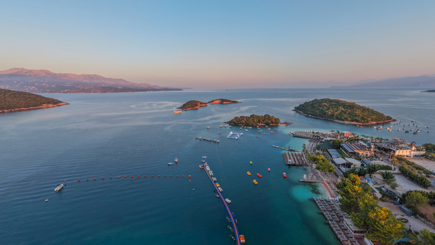 Aerial view of Ksamil islands and coastline with turquoise water sandy beaches sun loungers and small boats in Ksamil Vlore County Albania. Aerial view of Ksamil islands and coastline with turquoise water sandy beaches sun loungers and small boats in Ksamil Vlore County Albania.