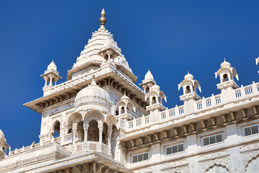 View of the white marble architecture of Jaswant Thada with its intricate domes carved pillars and balconies against a clear blue sky in Jodhpur Rajasthan India. View of the white marble architecture of Jaswant Thada with its intricate domes carved pillars and balconies against a clear blue sky in Jodhpur Rajasthan India.