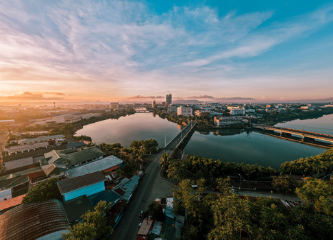Aerial view of a bridge spanning a wide reflective river amidst a cityscape bathed in the warm hues of dawn Iloilo City Philippines. Aerial view of a bridge spanning a wide reflective river amidst a cityscape bathed in the warm hues of dawn Iloilo City Philippines.