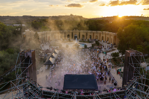 Attard Malta 20 September 2026 Aerial view of Park Nazzjonali Ta Qali during an outdoor music event with a large crowd stage scaffolding and golden hour sunlight. Attard Malta 20 September 2026 Aerial view of Park Nazzjonali Ta Qali during an outdoor music event with a large crowd stage scaffolding and golden hour sunlight.