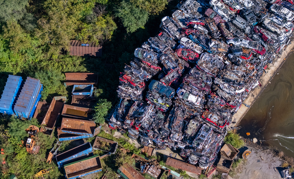 Aerial view of a scrap metal facility with large stacks of crushed cars and polluted water in Kalamazoo Michigan United States.