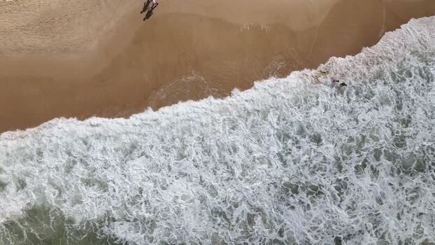 Aerial view of waves crashing on the sand at Copacabana Beach Brazil.