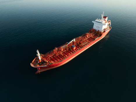 Aerial view of a large red oil tanker ship sailing on the calm blue waters of the Mediterranean Sea near Augusta Sicily Italy. Aerial view of a large red oil tanker ship sailing on the calm blue waters of the Mediterranean Sea near Augusta Sicily Italy.