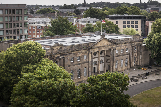 Aerial view of York Castle Museum with its neoclassical architecture surrounding lush trees and urban cityscape in York England United Kingdom.
