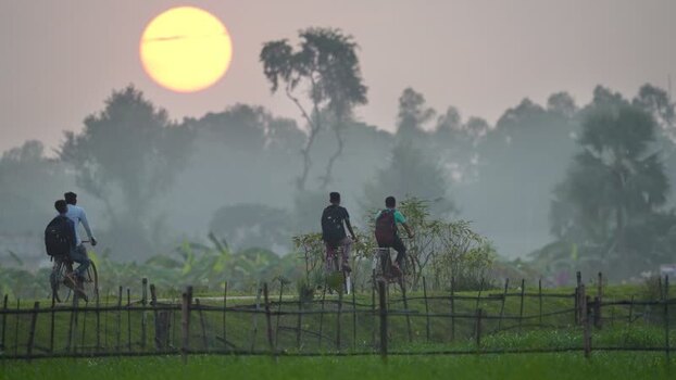 View of students cycling on a rural path during sunset Bangladesh. View of students cycling on a rural path during sunset Bangladesh.