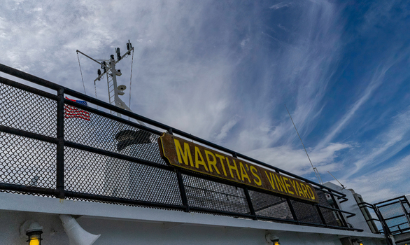 Edgartown United States 14 May 2026 View of the Martha s Vineyard sign on a ferry railing under a blue sky with wispy clouds and an American flag.