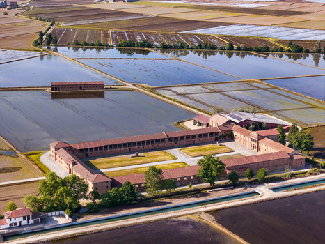 Aerial view of Tenuta Colombara historic farmstead surrounded by flooded rice paddies and rural fields in Livorno Ferraris Piemonte Italy.