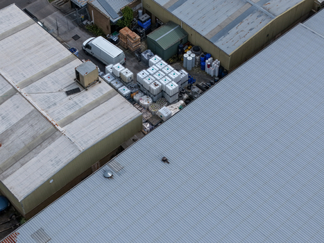 Melbourne VIC Australia 25 September 2026 Aerial view of industrial warehouses and storage area featuring a white van stacked containers and various industrial materials.