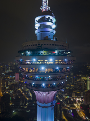 Kuala Lumpur Malaysia 11 March 2026 Aerial view of the illuminated Menara Kuala Lumpur tower at night with city lights in the background.