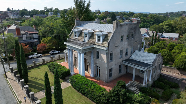 Aerial view of a historic mansion with white columns a slate roof and manicured lawns surrounded by lush trees in a residential neighborhood in Lynchburg Virginia United States. Aerial view of a historic mansion with white columns a slate roof and manicured lawns surrounded by lush trees in a residential neighborhood in Lynchburg Virginia United States.