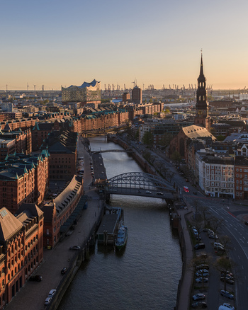 Aerial view of the Speicherstadt district with historic brick warehouses the Elbphilharmonie and St. Catherine s Church at sunset in Hamburg Hamburg Germany. Aerial view of the Speicherstadt district with historic brick warehouses the Elbphilharmonie and St. Catherine s Church at sunset in Hamburg Hamburg Germany.