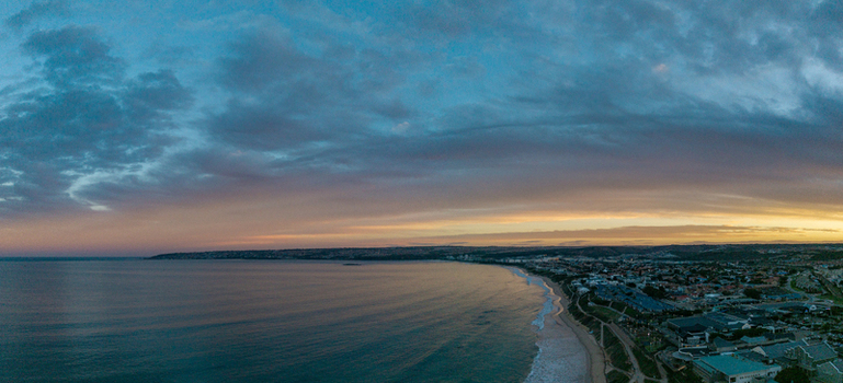 Aerial view of Hartenbos coastline with the calm ocean sandy beach and coastal town under a dramatic sunset sky Mossel Bay Western Cape South Africa. Aerial view of Hartenbos coastline with the calm ocean sandy beach and coastal town under a dramatic sunset sky Mossel Bay Western Cape South Africa.