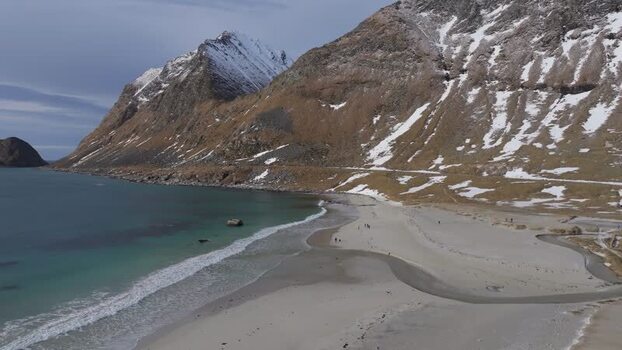 Aerial view of Lofoten beach with snow capped mountains Norway.