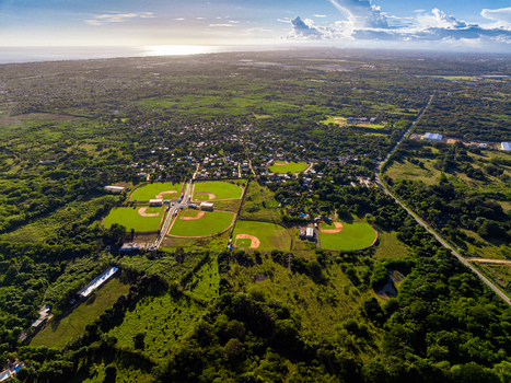 Aerial view of Quality Baseball Academy with baseball fields surrounded by lush tropical vegetation and rural landscape in San Antonio de Guerra Santo Domingo Provinc Dominican Republic. Aerial view of Quality Baseball Academy with baseball fields surrounded by lush tropical vegetation and rural landscape in San Antonio de Guerra Santo Domingo Provinc Dominican Republic.