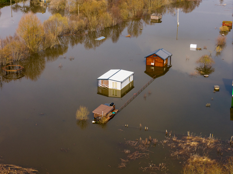 Aerial view of small houses and cabins surrounded by floodwaters and bare trees in Kedainiai Kaunas County Lithuania. Aerial view of small houses and cabins surrounded by floodwaters and bare trees in Kedainiai Kaunas County Lithuania.