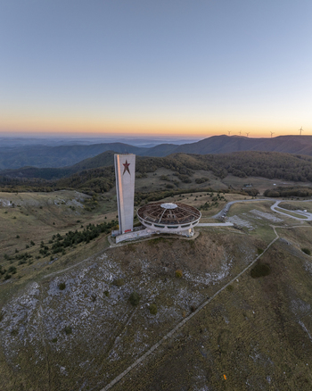 Aerial view of the Buzludzha Monument a brutalist saucer shaped structure with a tall tower featuring a red star situated on a mountain peak in Stara Zagora Bulgaria. Aerial view of the Buzludzha Monument a brutalist saucer shaped structure with a tall tower featuring a red star situated on a mountain peak in Stara Zagora Bulgaria.