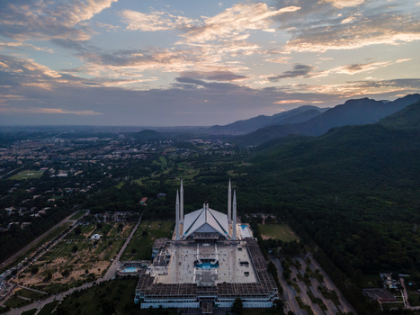 Aerial view of Faisal Masjid and its white minarets at the foot of the Margalla Hills during sunset in Islamabad Islamabad Capital Ter Pakistan. Aerial view of Faisal Masjid and its white minarets at the foot of the Margalla Hills during sunset in Islamabad Islamabad Capital Ter Pakistan.
