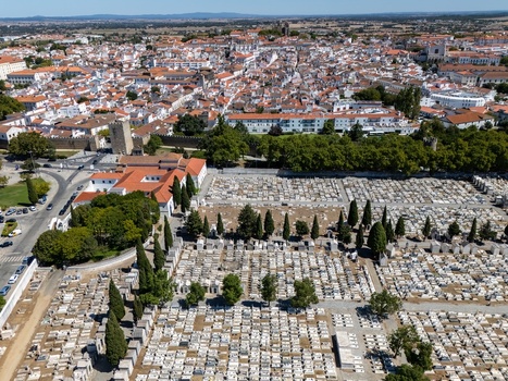 Aerial view of the cemetery with rows of white tombs and cypress trees situated next to the historic city center of Evora Evora District Portugal. Aerial view of the cemetery with rows of white tombs and cypress trees situated next to the historic city center of Evora Evora District Portugal.