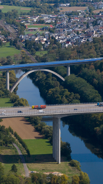 Aerial view of the Lahn Valley Bridge spanning the river Lahn with highway traffic and the town of Limburg an der Lahn in the background in Limburg an der Lahn Hessen Germany.