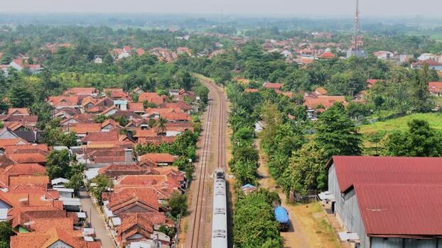 Aerial view of a train passing through a town in Indonesia. Aerial view of a train passing through a town in Indonesia.