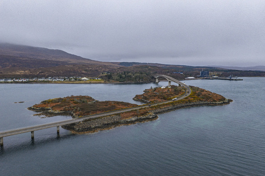 Aerial view of the Skye Bridge spanning across the water and small islands under an overcast sky Isle of Skye Scotland United Kingdom.