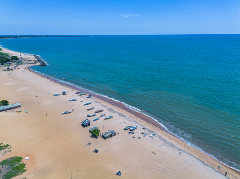 Aerial view of Negombo Beach with traditional fishing boats resting on the sandy shore along the turquoise waters of the Indian Ocean in Negombo Western Province Sri Lanka. Aerial view of Negombo Beach with traditional fishing boats resting on the sandy shore along the turquoise waters of the Indian Ocean in Negombo Western Province Sri Lanka.